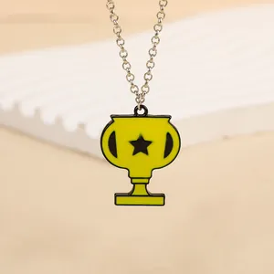 Vue macro du collier pendentif trophée avec finition jaune et détail d'étoile sur socle