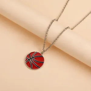Gros plan d'un collier chaîne argenté avec un pendentif de basket-ball rouge et noir détaillé