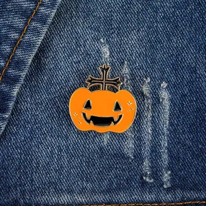 Macro shot of Halloween pumpkin enamel pin with black cross on denim fabric