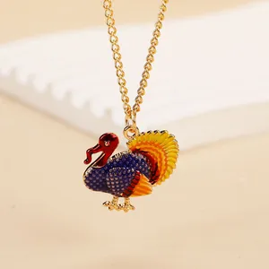 Macro detail of enamel turkey pendant with colorful feathers and gold-plated chain