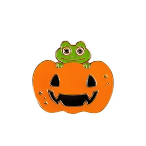 Detailed close-up of a Halloween enamel pin featuring a green frog inside a pumpkin