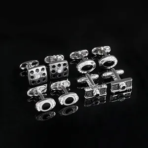 Detailed view of silver cufflinks with black enamel, crystals and camera designs