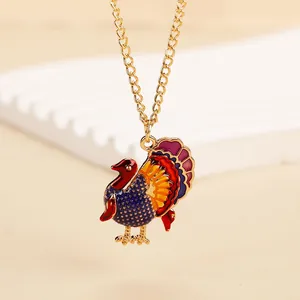 Macro view of a colorful enamel turkey pendant with gold chain for Thanksgiving