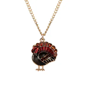 Detailed view of colorful turkey pendant necklace with enamel details and gold wave chain