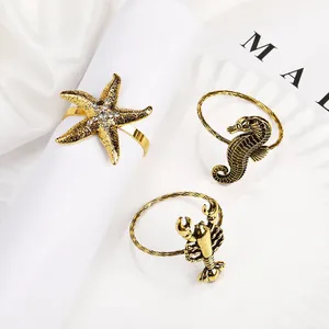 Detalle de un servilletero de estrella de mar dorado vintage con strass sobre blanco