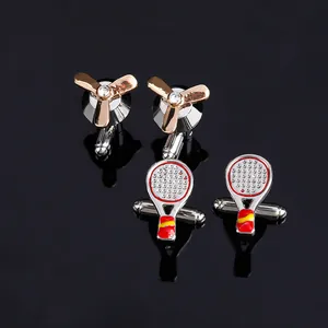 Silver tennis racket and golden propeller cufflinks set with crystal accents on black