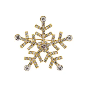 Detailed view of a golden snowflake brooch featuring sparkling rhinestones and pearl accents