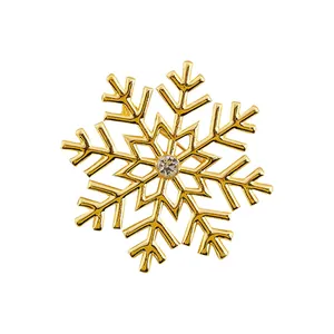 Close-up of a gold snowflake brooch with centered pearl and sparkling crystal accents