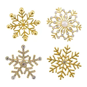 Golden snowflake brooch set with rhinestones and pearls on white background