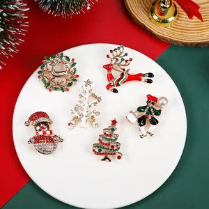 Flat lay of festive Christmas brooches with reindeer and wreath on holiday background