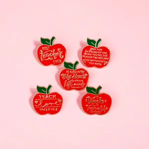 Detailed view of five red enamel apple pins with gold edges and teacher appreciation quotes