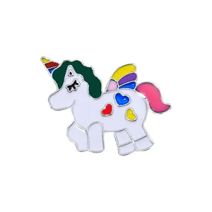 Detailed view of enamel unicorn pin with colorful mane and heart-shaped wing accents