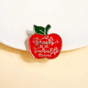 Detail of red apple enamel pin with Teacher quote To Teach Is To Touch a Life Forever