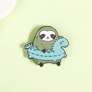 Macro shot of sloth enamel pin with dinosaur swim ring on minimalist green background