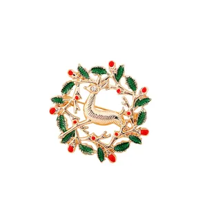 Detailed view of a golden Christmas reindeer brooch with green holly leaf wreath