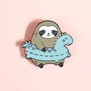 Detailed close-up of cartoon sloth in a blue dinosaur swim ring enamel pin design