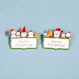 Détail de pin's de Noël en émail avec le Père Noël, un renne et texte Merry Christmas