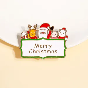 Détail de la broche de Noël en émail coloré avec inscription festive Merry Christmas