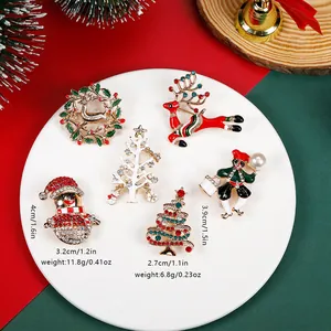 Christmas tree and Santa brooches with colorful rhinestones on festive background