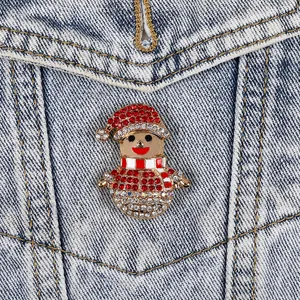 Charming Christmas elf brooch with red rhinestones pinned on a blue denim jacket pocket