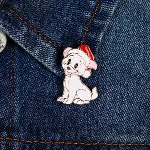 Detail of white cartoon puppy enamel pin with red Christmas hat on denim jacket collar