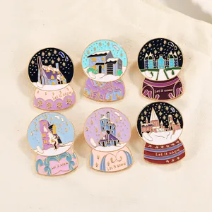 Set of six enamel pins with snowy castle designs and golden Let it snow text