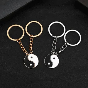 Dettaglio dei portachiavi dell'amicizia Yin Yang in oro e argento su sfondo nero