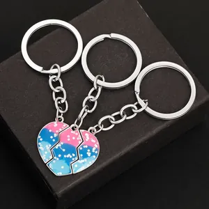 Detailed view of three-piece heart puzzle keychains with pink and blue glitter finish