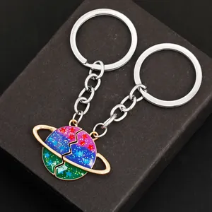 Detailopname van bijpassende planeet sleutelhangers met Saturnus op een geschenkdoos