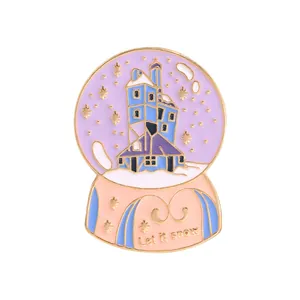 Detail of Let It Snow enamel pin featuring a winter castle inside a magic crystal ball