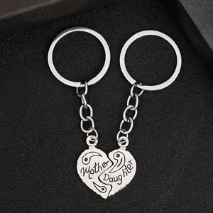 Detailweergave van zilveren hartvormige sleutelhangers met Mother en Daughter gravure