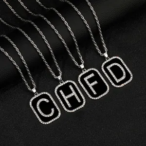 Detalle macro de collares hip hop con colgantes rectangulares negros con letras y cristales