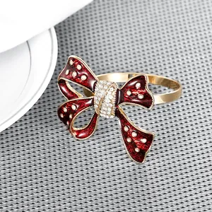 Close-up of red enamel bow napkin ring with sparkling rhinestones and golden finish