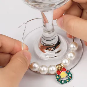 Christmas wine glass marker with pearl beads and red bow wreath charm on a glass stem