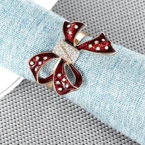 Detailed close-up of a burgundy bow napkin ring with sparkling rhinestones and gold band
