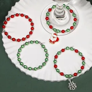 Detail of Christmas wine glass charms with beads, Santa and Xmas tree pendants in a ceramic tray