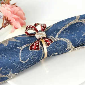 Detail of red bow napkin ring with clear crystals on a textured blue napkin