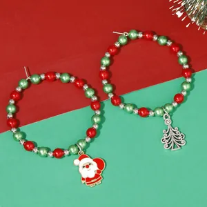 Close-up of Christmas beaded hoop earrings with Santa Claus and silver Xmas tree charms