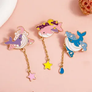 Set of three whale enamel pins in pink purple and blue with star and wave pendants