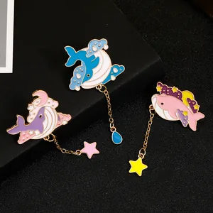 Detailed view of ocean whale enamel brooches featuring dangling stars and water drops