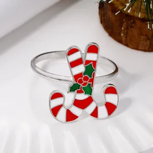 Detail of candy cane napkin ring with red stripes and green holly on silver band