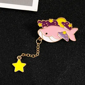 Detail of pink enamel whale brooch with purple clouds and dangling star chain