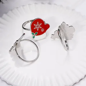 Detail of red enamel glove napkin ring with white snowflake and green holly motifs