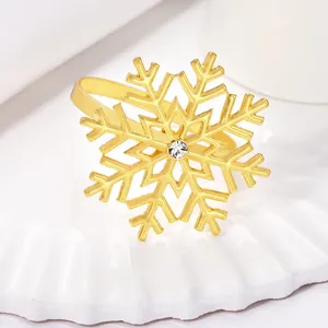 Close-up of golden snowflake napkin ring with crystal center on white ceramic