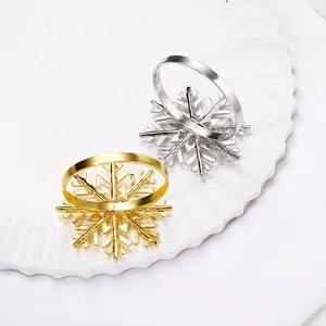 Close-up of snowflake napkin rings in gold and silver finish on a ceramic plate