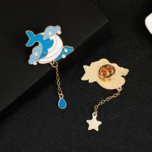 Detailed close-up of whale enamel brooch with chain pendant and butterfly clasp back