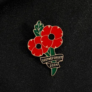 Détail de la broche coquelicot en émail rouge avec inscription dorée Lest We Forget 2024