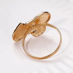Nahaufnahme des goldenen Schmetterlings-Serviettenrings mit Strass auf einem Teller