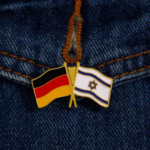 Close-up of metal enamel pin featuring crossed German and Israel flags on denim fabric