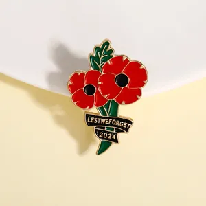 Détail d'une broche coquelicot en émail rouge avec ruban Lest We Forget 2024